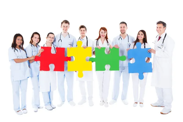 Medical team holding colorful puzzle pieces — Stock Photo, Image