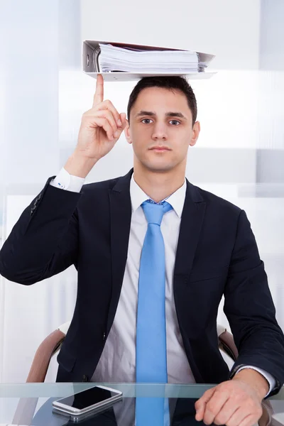 Geschäftsmann balanciert Bindemittel mit Finger — Stockfoto