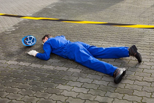 Joven técnico inconsciente yaciendo en la calle — Foto de Stock