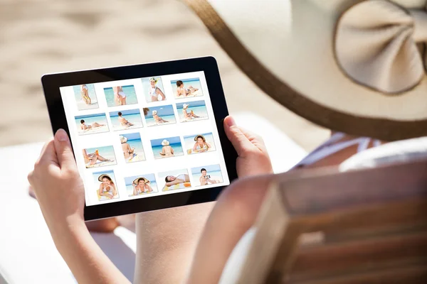 Kvinna som tittar på hennes bilder på digitala tablett — Stockfoto