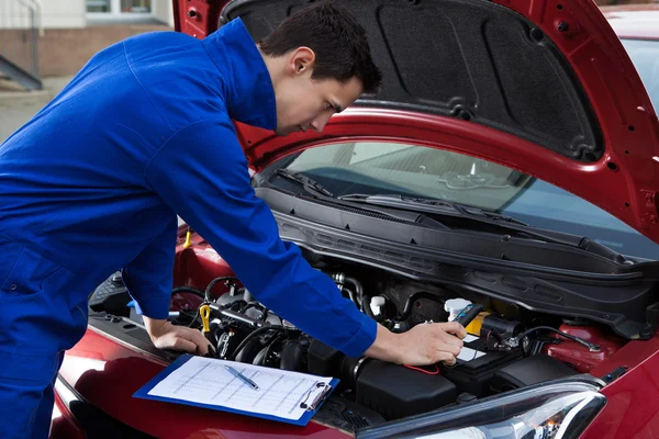Mechaniker in Uniform repariert Auto — Stockfoto