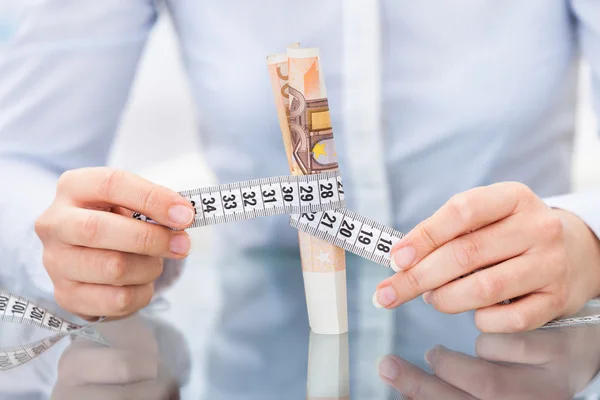 Empresario con cinta métrica y billete — Foto de Stock