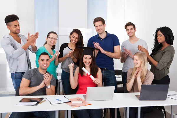 Studenten klappen voor klasgenoot bedrijf graad — Stockfoto