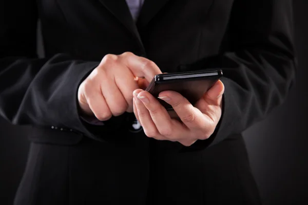Бизнесмен, держащий мобильный телефон — стоковое фото