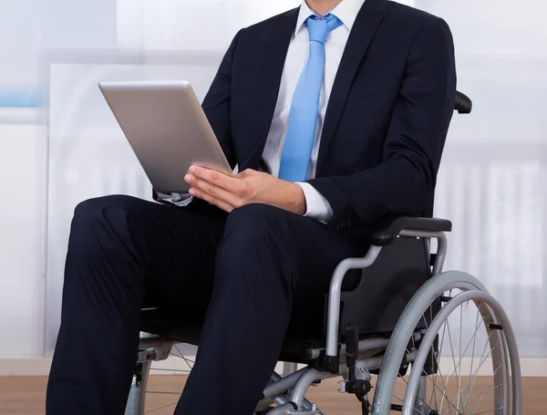 Uomo d'affari che utilizza tavoletta digitale sulla sedia a rotelle — Foto Stock