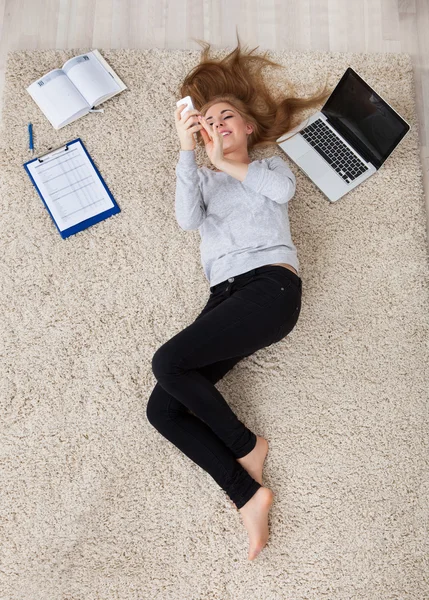 Mujer joven acostada en la alfombra — Foto de Stock