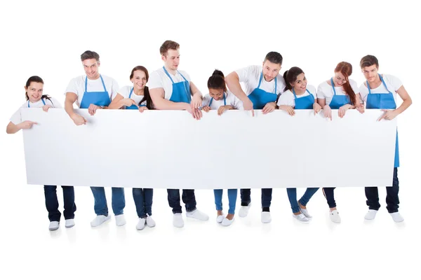 Grupo de limpadores segurando um banner branco em branco — Fotografia de Stock