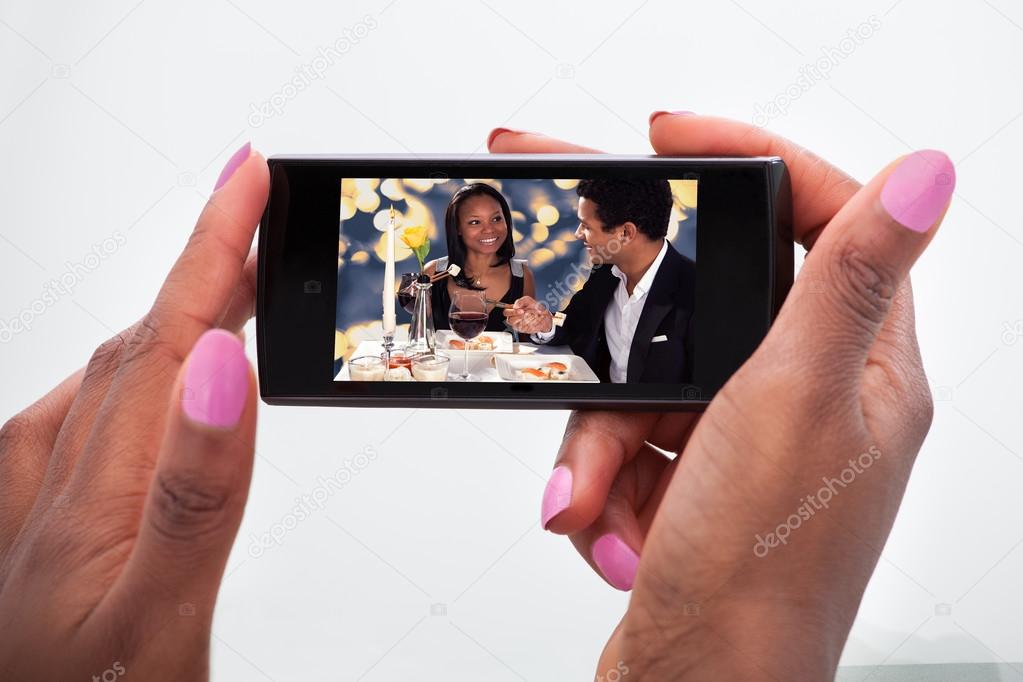 Woman Watching Video On Mobile Phone At Home