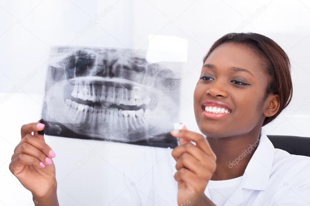 Female dentist looking at jaw Xray in clinic