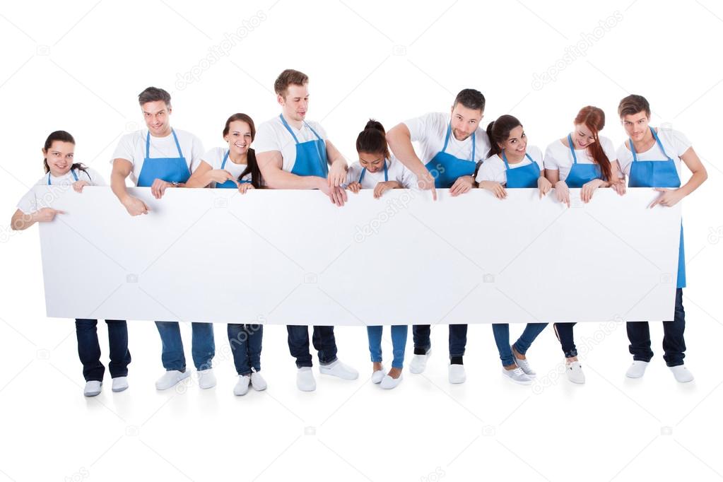 Group of cleaners holding a blank white banner