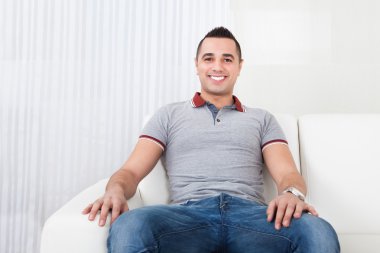 mutlu genç adam kanepede oturan