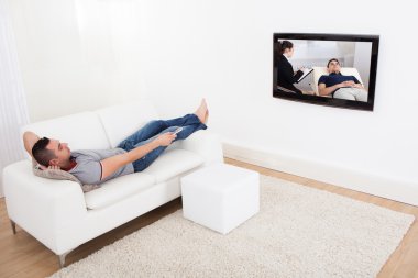 adam kanepede televizyon izlerken