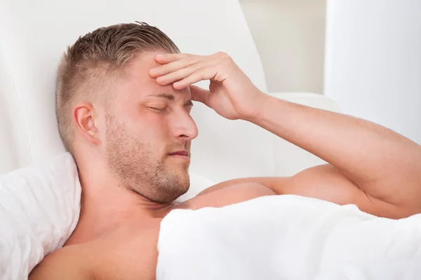 Homem acordando com uma dor de cabeça desagradável — Fotografia de Stock