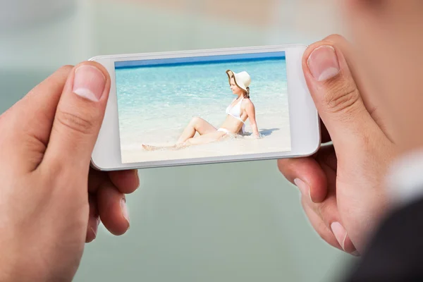 Cropped image of businessman watching woman at beach — Stock Photo, Image
