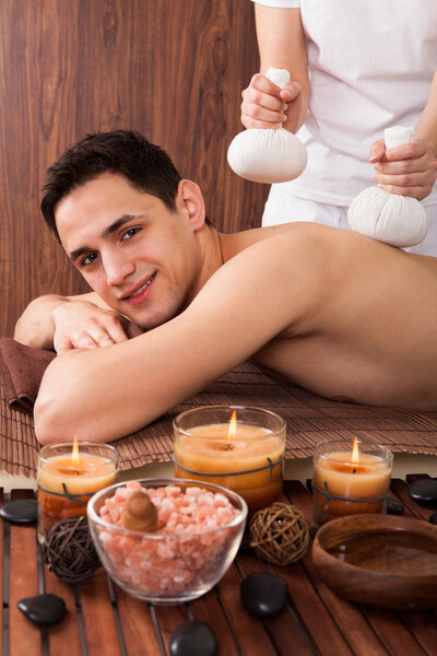 Man Receiving Massage With Stamps In Spa