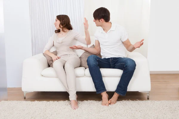 Retrato de casal sentado no sofá tendo briga — Fotografia de Stock