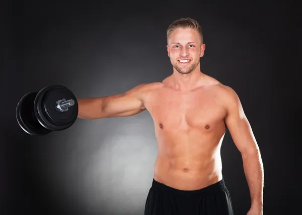 Muscular fit young man working out with weights — Stock Photo, Image