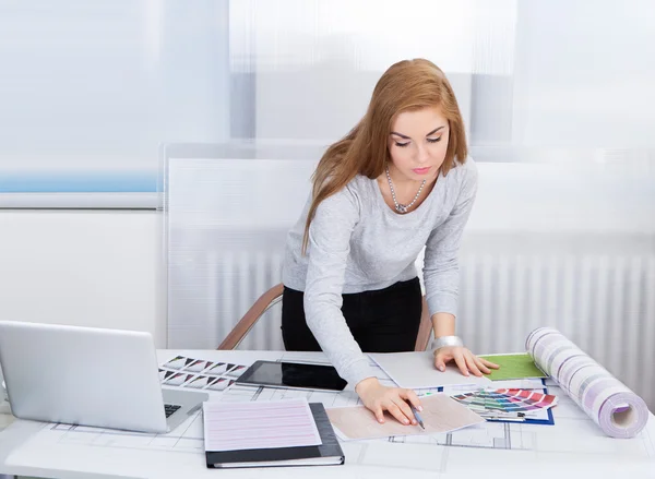Mujer joven trabajando en el escritorio de la oficina —  Fotos de Stock