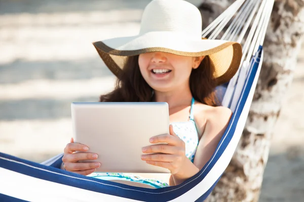 Glückliche Frau mit digitalem Tablet in der Hängematte — Stockfoto