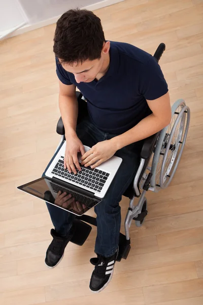 Homem deficiente usando laptop na cadeira de rodas — Fotografia de Stock