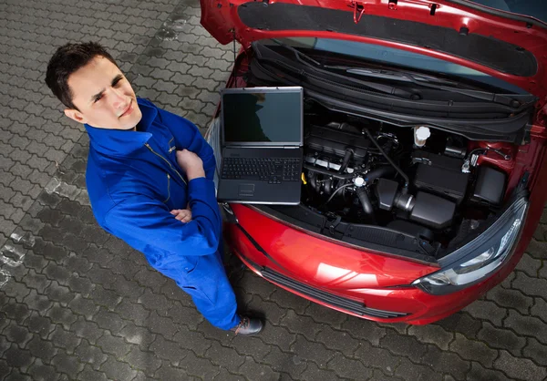 Meccanico con le braccia incrociate in piedi in auto — Foto Stock