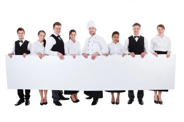 Group of catering staff holding a blank banner — Stock Photo, Image