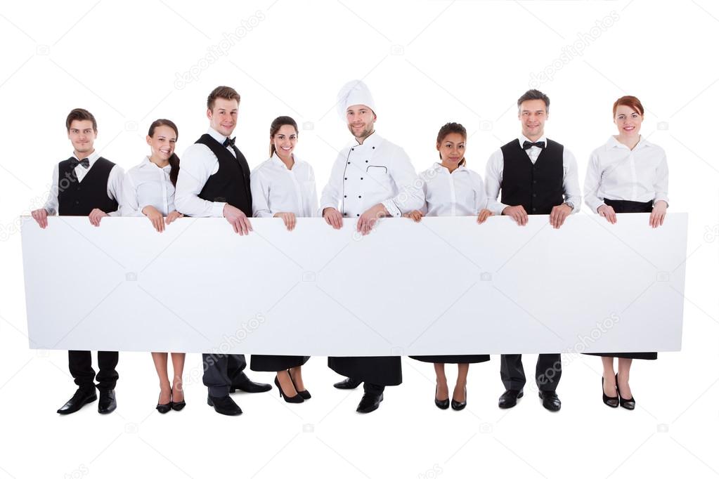 Group of catering staff holding a blank banner