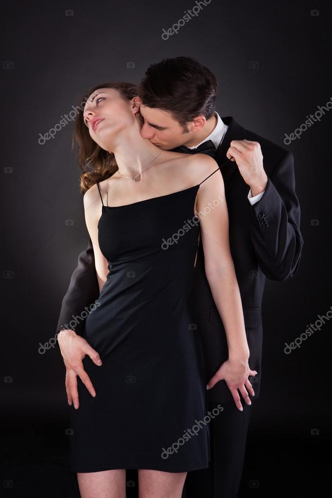 Man Kissing Woman On Neck While Removing Dress Strap Stock Photo by ...