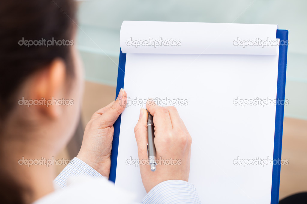 Businesswoman Writing On Clipboard