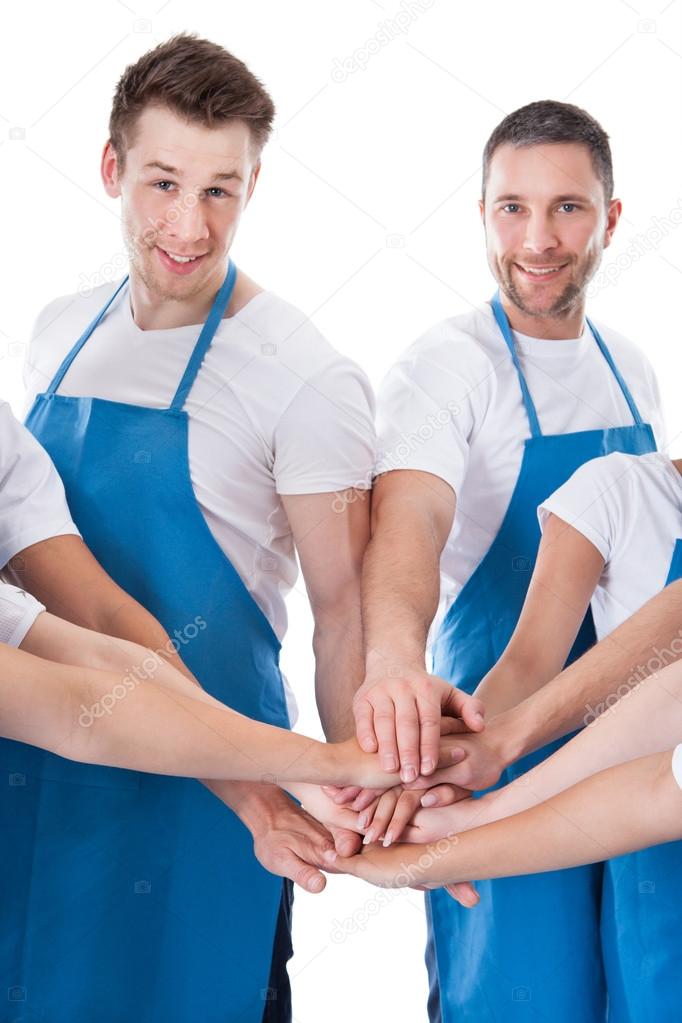 Group of cleaners stacking hands