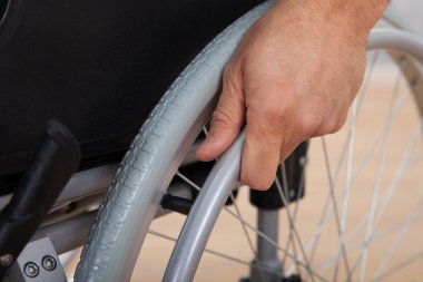 Handicapped Man's Hand Pushing Wheel Of Wheelchair clipart