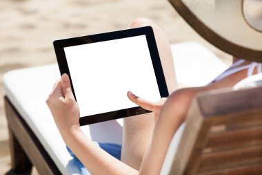 Dijital tablet plaj sandalye kullanan kadın