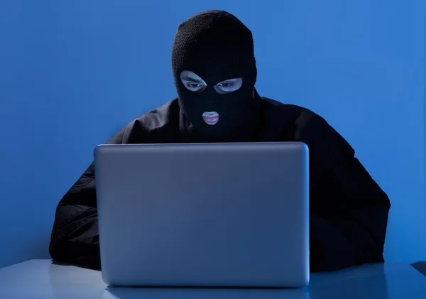 Criminelle à l'aide d'un ordinateur portable pour pirater compte en ligne — Photo
