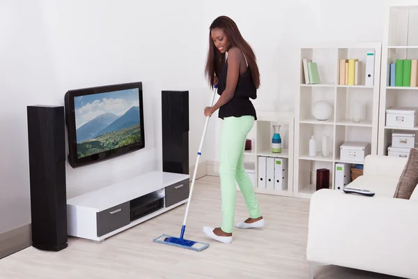 Mulher limpeza chão na sala de estar — Fotografia de Stock