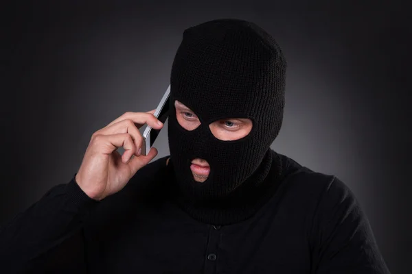 Thief using a stolen mobile phone — Stock Photo, Image