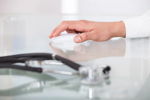 Cropped image of doctor's hand using mouse — Stock Photo, Image