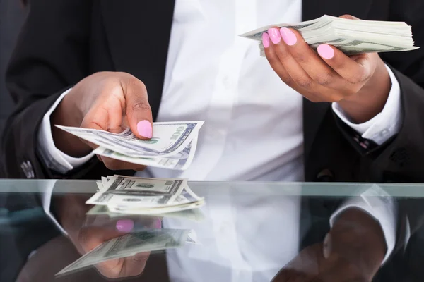 Empresária contando notas de dólar na mesa no escritório — Fotografia de Stock