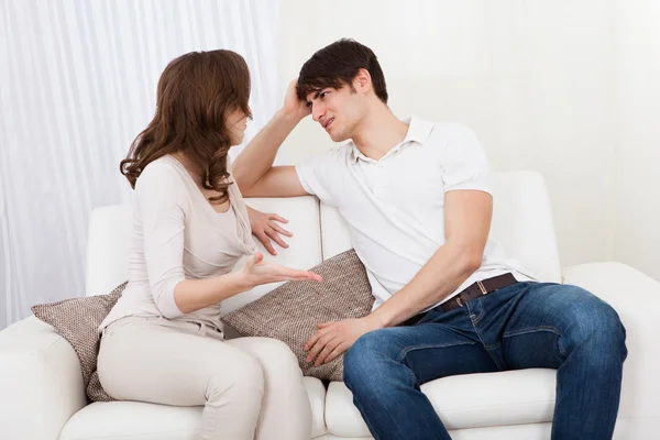 Retrato de pareja sentada en sofá discutiendo — Foto de Stock