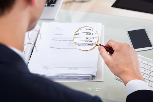 Auditor Examinando Fatura com Lupa — Fotografia de Stock