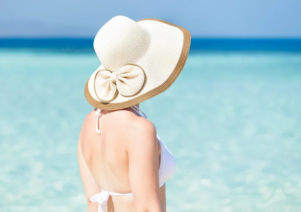 Mulher vestindo chapéu de sol na praia — Fotografia de Stock