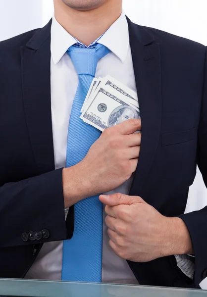 Empresario poniendo dinero de soborno en el bolsillo — Foto de Stock