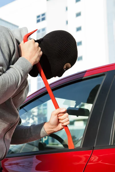 Dief in hooded jas en balaclava openen van auto deur — Stockfoto