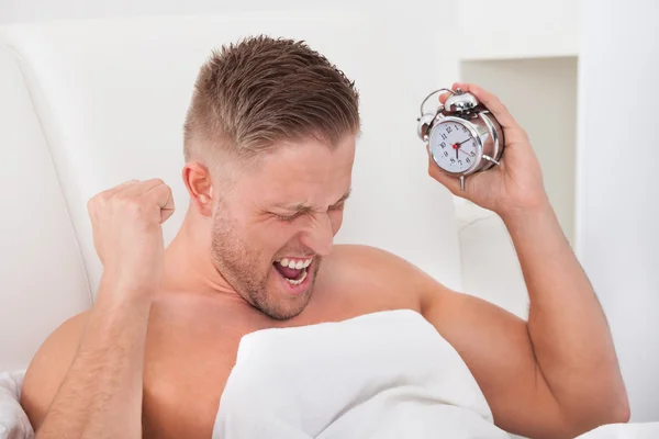 Homem gritando de frustração em seu despertador — Fotografia de Stock