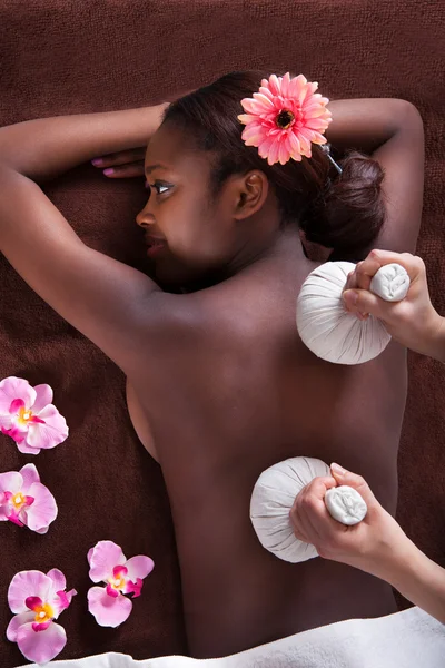 Mujer disfrutando de masaje a base de hierbas en el spa —  Fotos de Stock