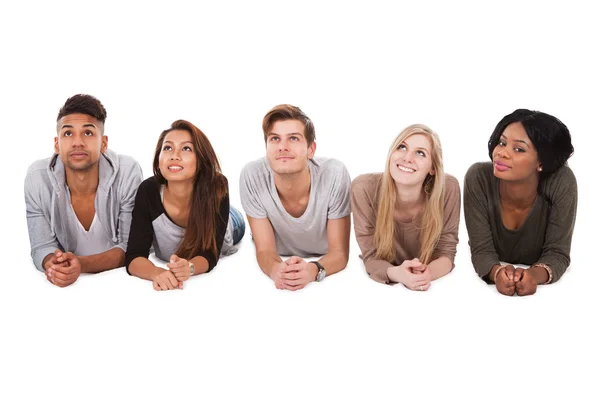 Multiethnic Students Lying Over White Background — Stock Photo, Image