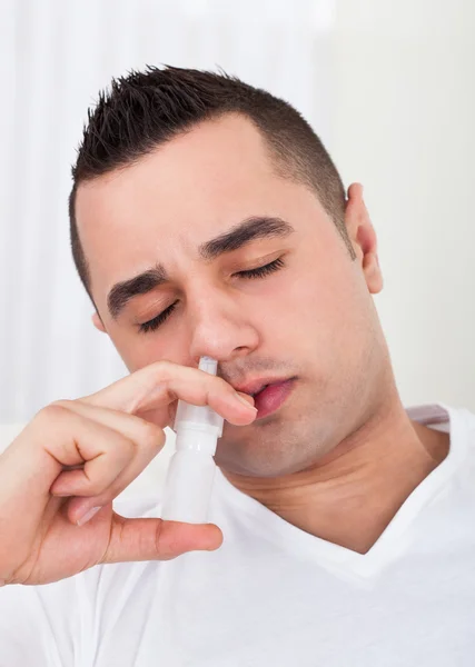 Uomo spruzzando gocce nel naso — Foto Stock