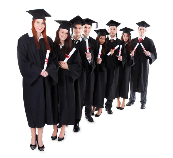 Graduate students standing in row holding diplomas — Stock Photo, Image