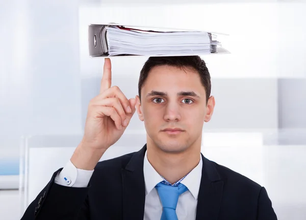 Empresario Equilibrio carpeta en la cabeza con dedo — Foto de Stock