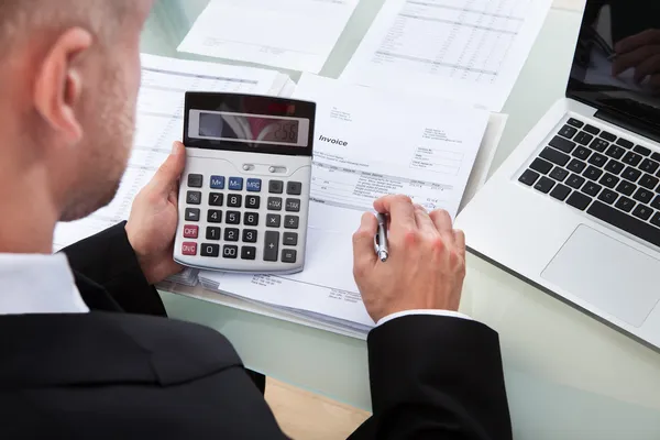 Empresario verificando cifras en un informe — Foto de Stock