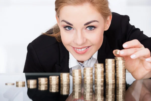 Mujer de negocios apilando monedas — Foto de Stock